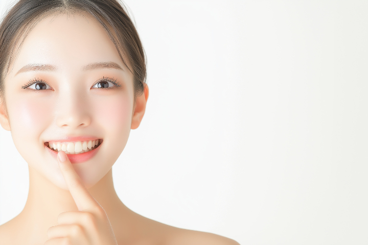 虫歯治療した歯を指さして笑顔をみせる女性