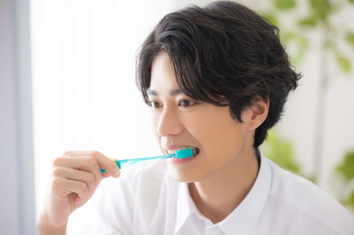 セラミック治療後に丁寧に歯みがきをする男性