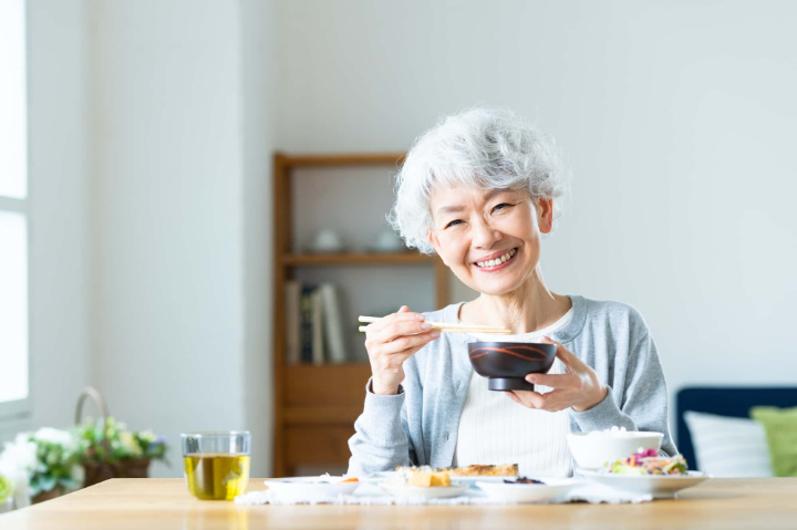 インプラント治療をして快適に食事をする女性