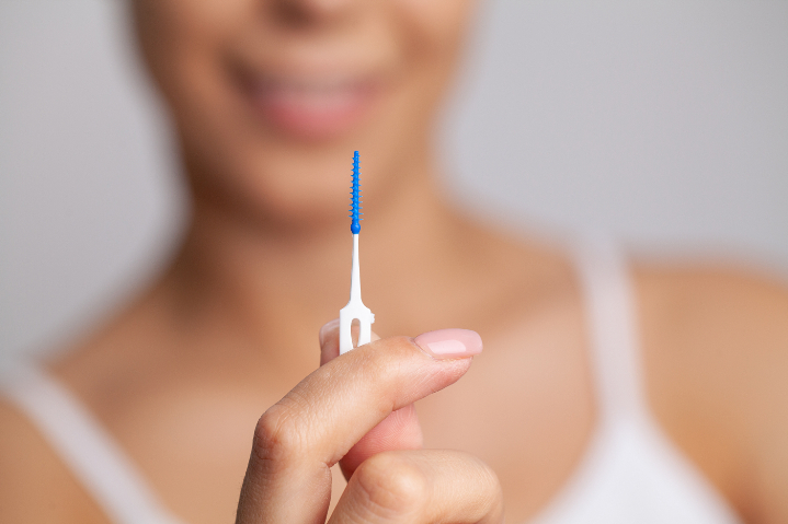 初期の虫歯を歯間ブラシでケアする女性