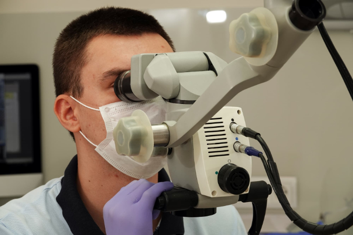 マイクロスコープで根管治療をする歯科医
