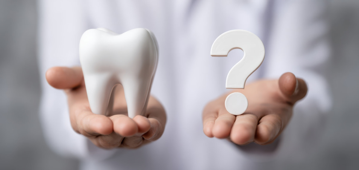 セラミックの歯が原因で口臭が発生するのかという疑問を示す歯の模型とハテナマーク