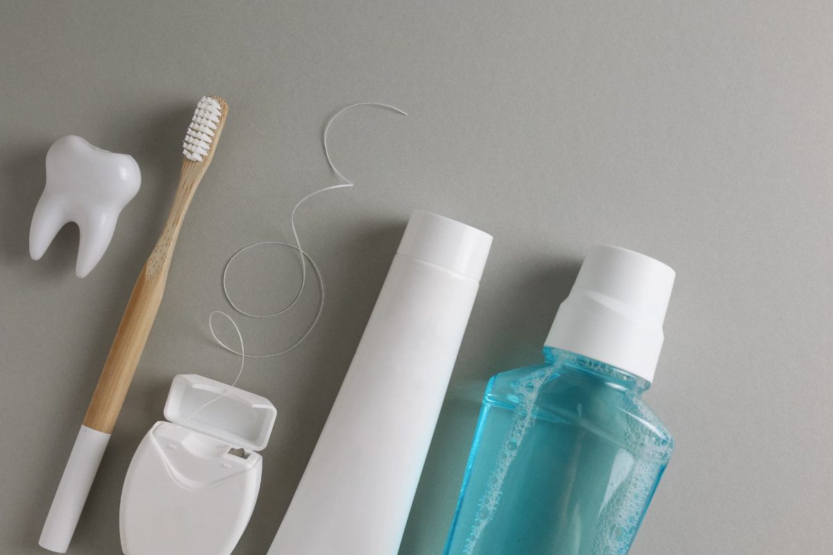 歯の模型と口腔ケアのための歯ブラシやフロスやマウスウォッシュ