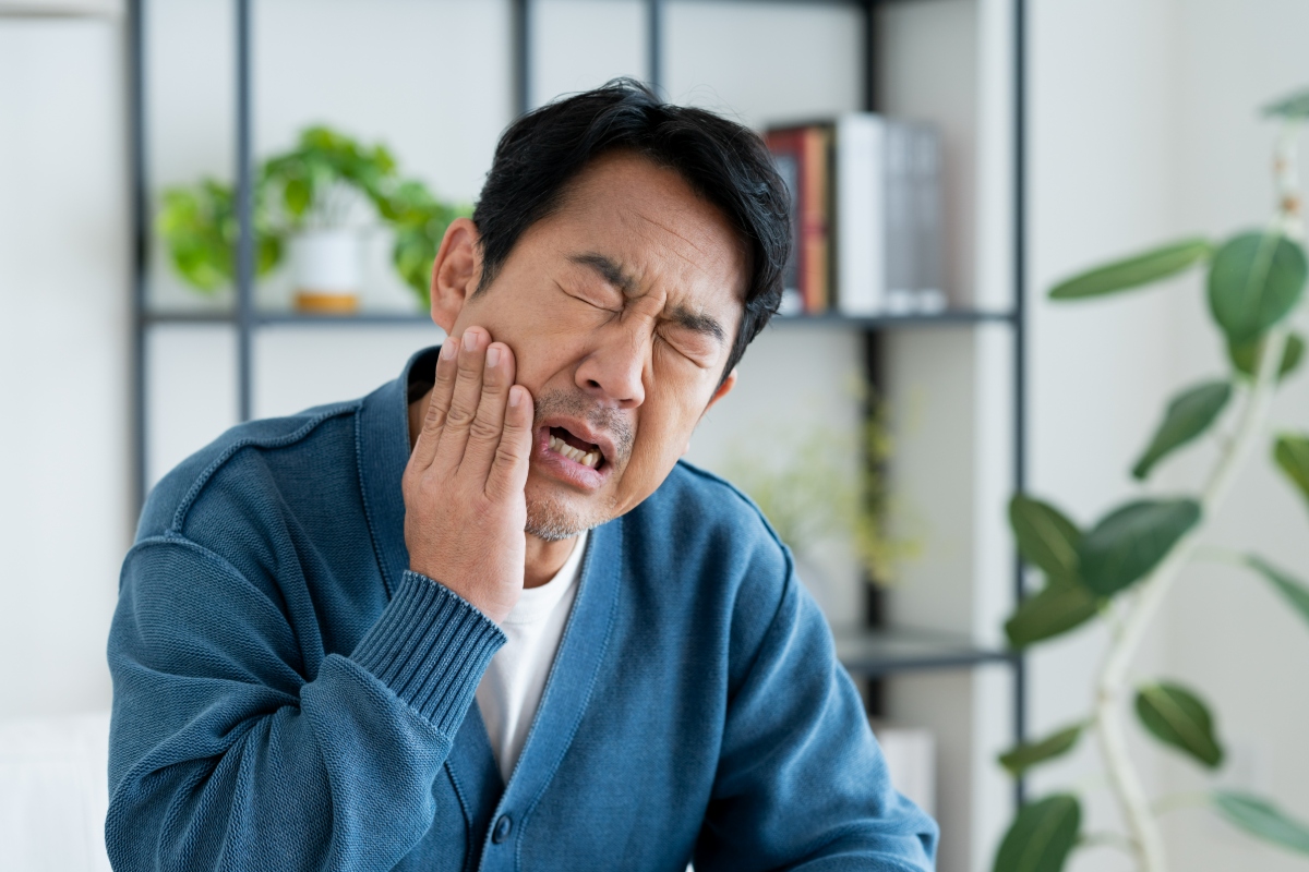 矯正治療で痛みが生じている男性