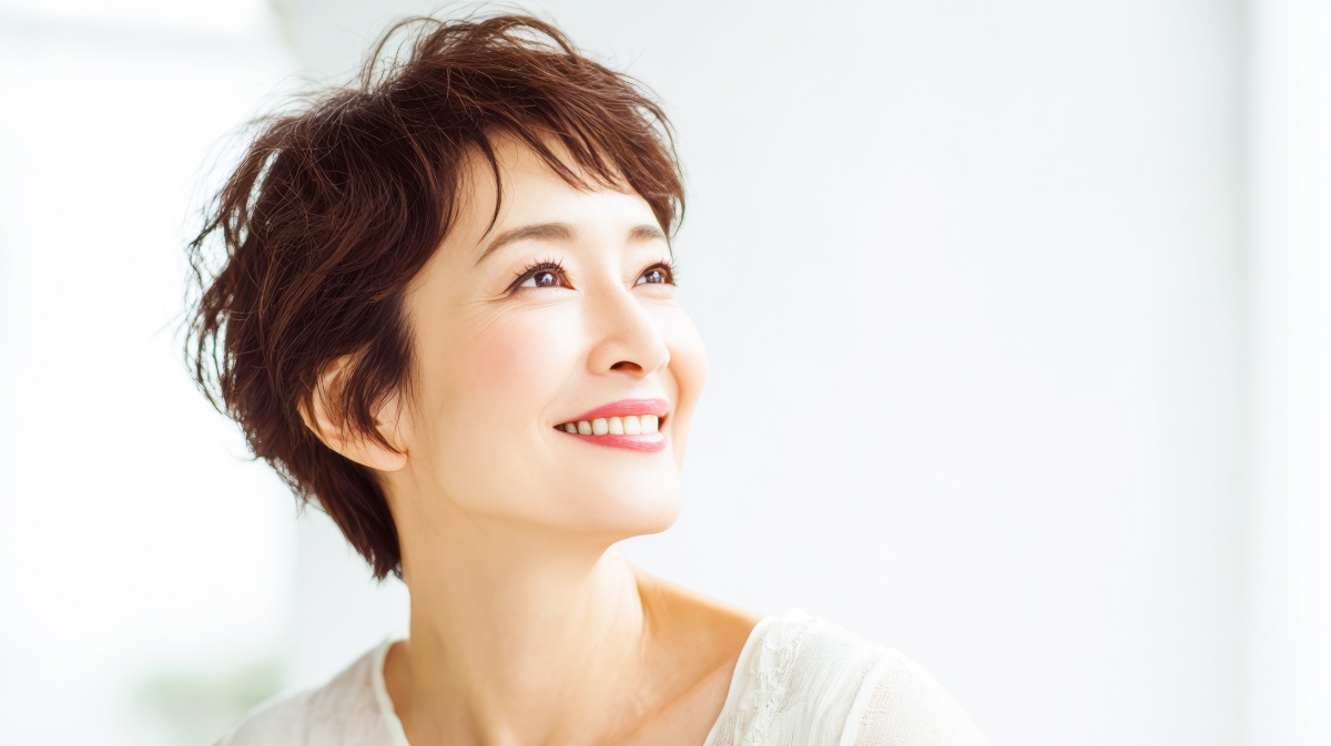 審美歯科治療で美しい歯をした笑顔のミドル女性
