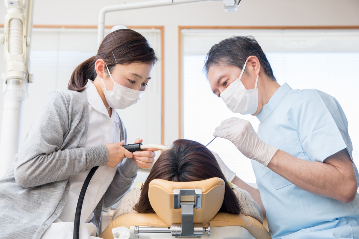 根管治療中の歯科医と患者